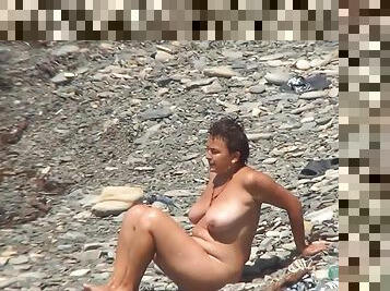 Sexy busty brunette is getting naked outdoors