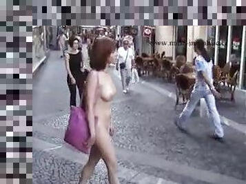 Redhead walking down a European street nude