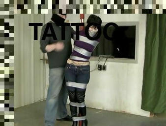 Johannie in sexy boots taped to a pole and wrap gagged tightly