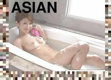 Cute asian girl fingers her hairy pussy in the bathtub