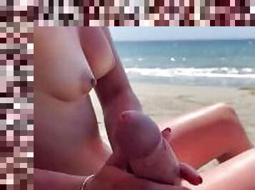 Handjob on a public beach with cumshot