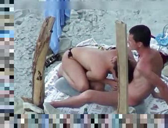A couple is spying on camera at the beach