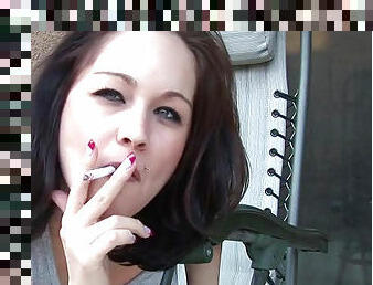 Sensual brunette is smoking a cigarette