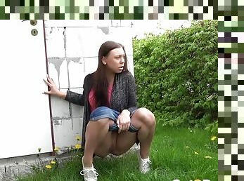 Denim shorts girl walks into the yard to piss