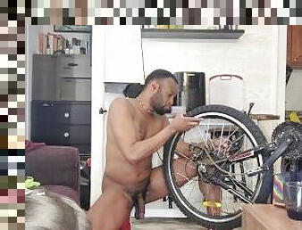 Kennie Jai repairs his electric bike in the nude.